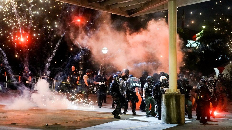 A firework explodes near a police line during a protest in Atlanta, Georgia, in response to the police killing of George Floyd, 30 May 2020