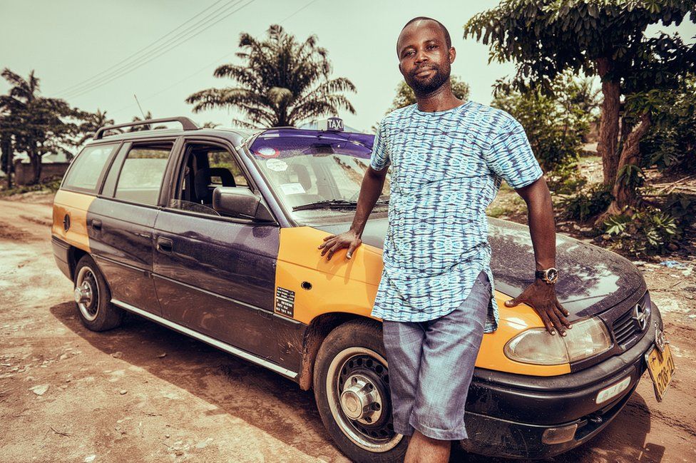 A man stands next to his taxi