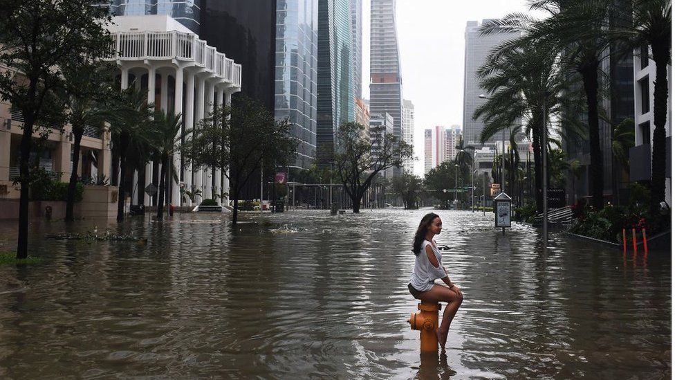 Woman sat on fire hydrant in flooded Downtown Miami