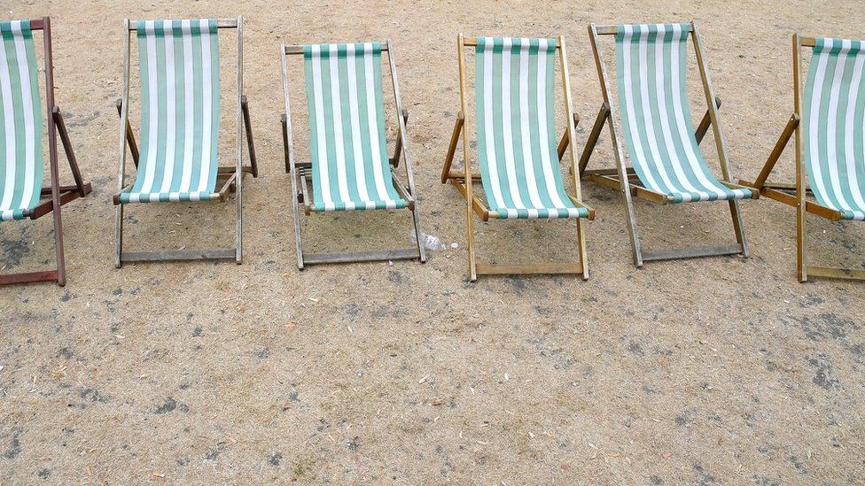 Deckchairs are seen on parched grass in Hyde Park in London.