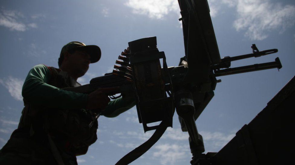 An Afghan government soldier behind a machine gun