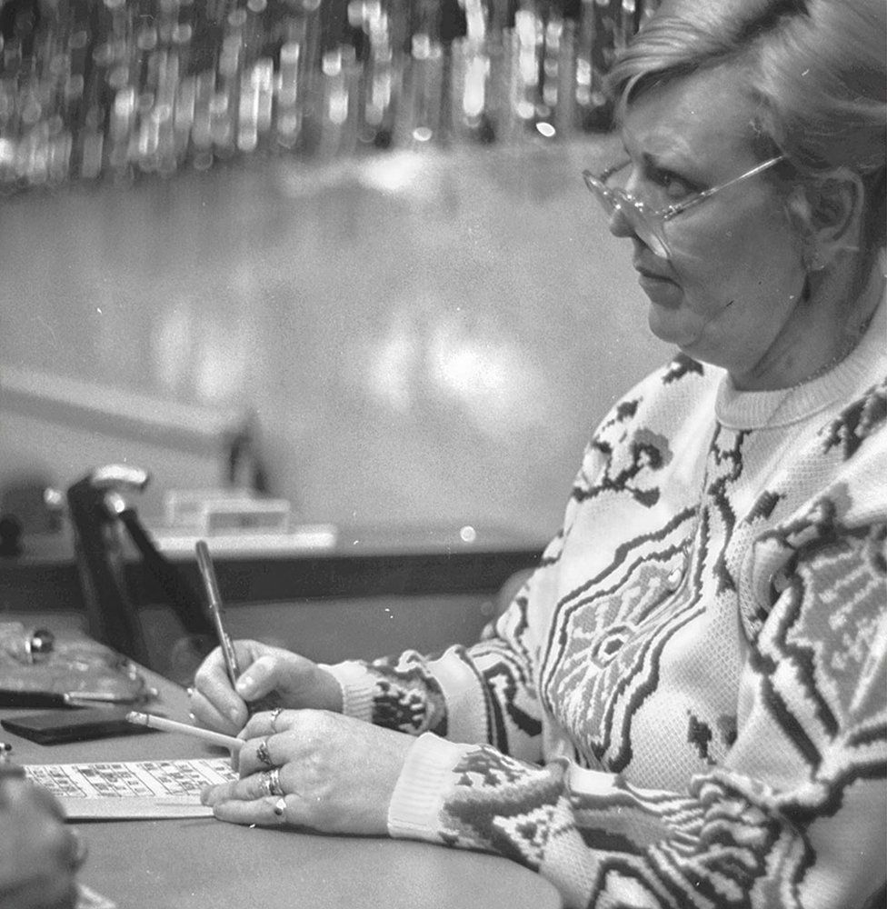 A lady smoking while playing bingo