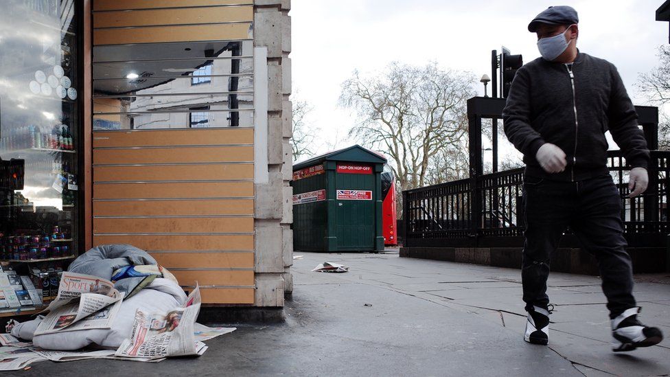A man walks past a pile of a homeless person's belongings in a doorway at the Marble Arch end of Oxford Street in London