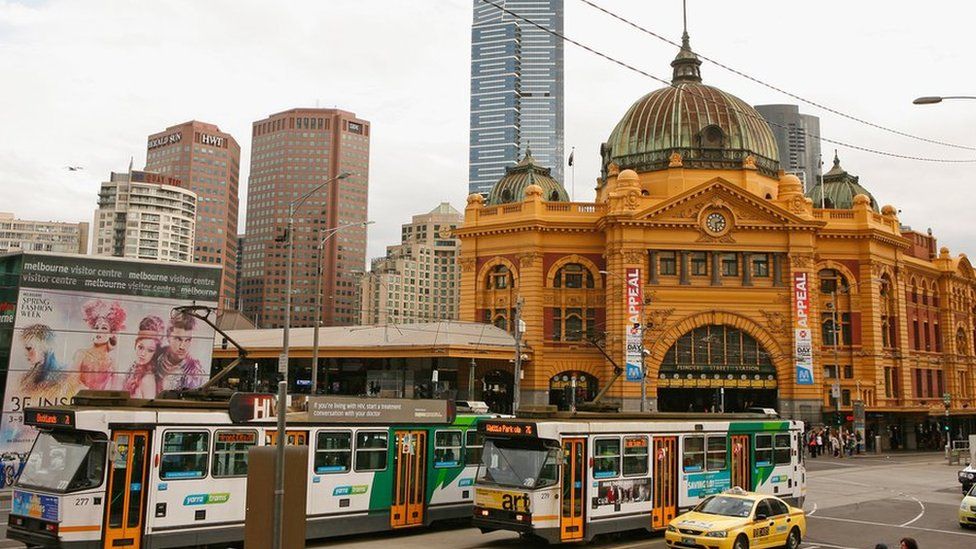 Trams go past Flinders Street Train station in Melbourne's CBD