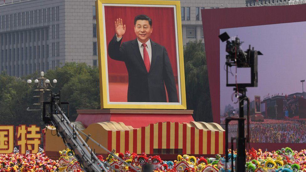 A float with a giant portrait of Chinese President Xi Jinping passes by Tiananmen Square