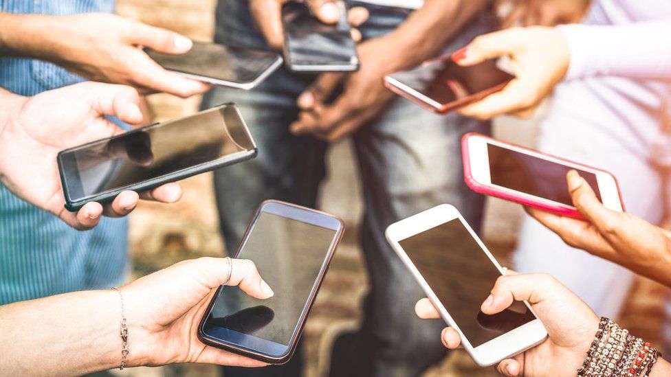 Teenagers using social media on their mobile phones