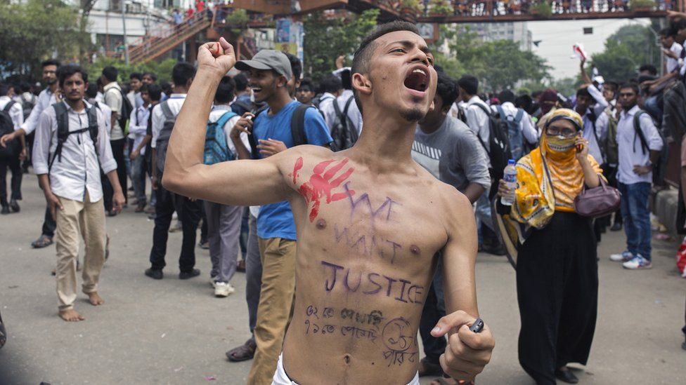 A Bangladeshi student shout slogans while blocking a road with others during a rally demanding safe roads on the seventh consecutive day of protests