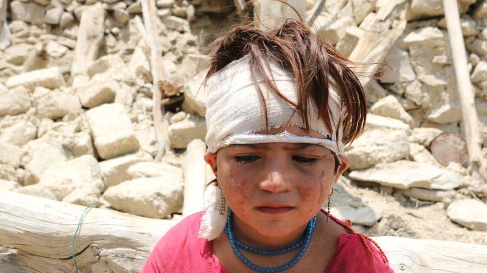 Child outside destroyed home in Khost area