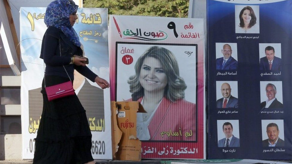 Woman walks past campaign poster in Amman (15/09/16)
