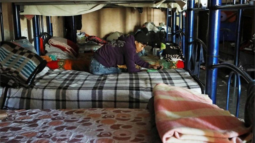A migrant sits on a bed in El Buen Samaritano shelter in Ciudad Juarez