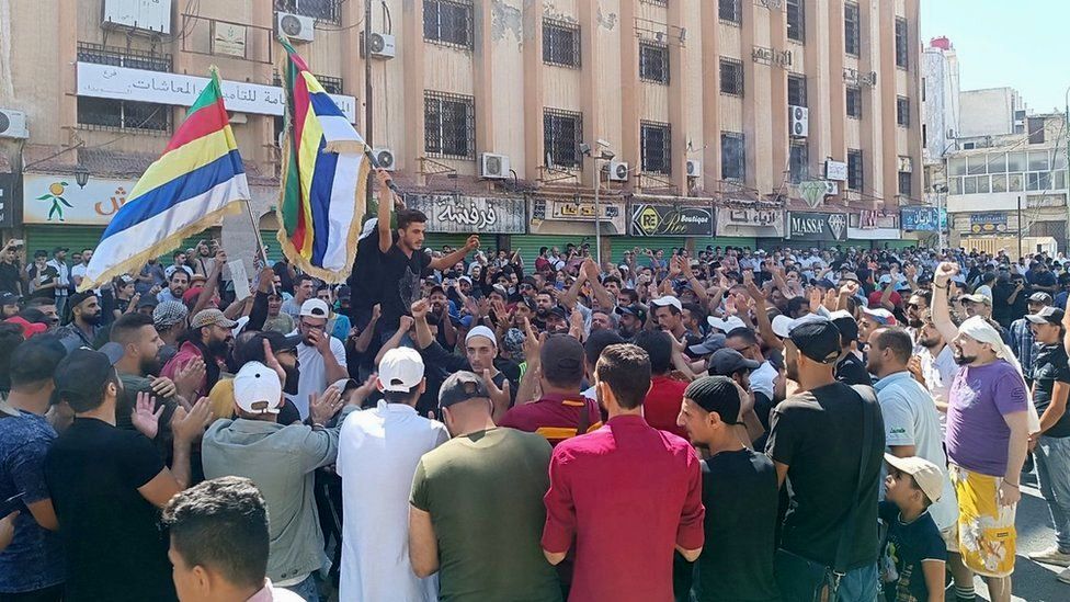 Люди принимают участие в антиправительственном протесте на площади Аль-Сайр в Сувейде, южная Сирия (22 августа 2023 г.)