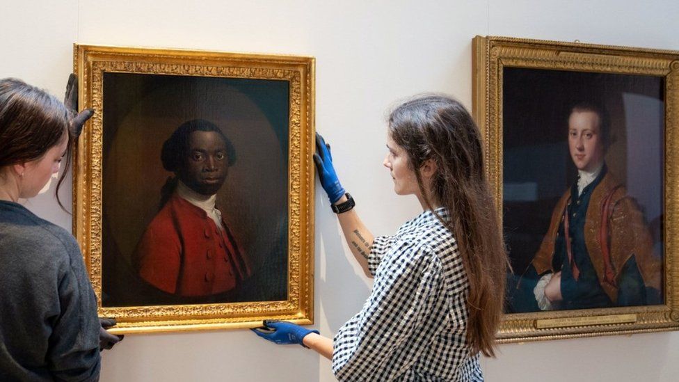 Portrait of a Man in a Red Suit, c.1740-80, being lent by the Royal Albert Memorial Museum in Exeter, is hung next to portrait of the museum's founder during a photo call to mark the opening of Cambridge's Fitzwilliam Museum's new Black Atlantic: Power, People, Resistance exhibition.