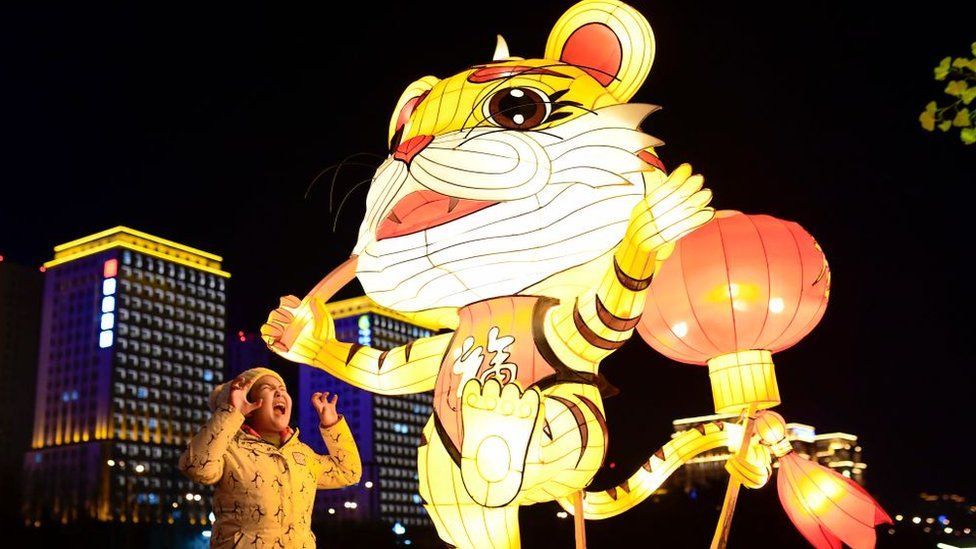 A child interacts with the street lighting of Auspicious Tiger in Hohhot, Inner Mongolia, China.
