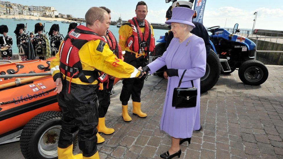 The Queen shakes the hand of an RNLI crew member