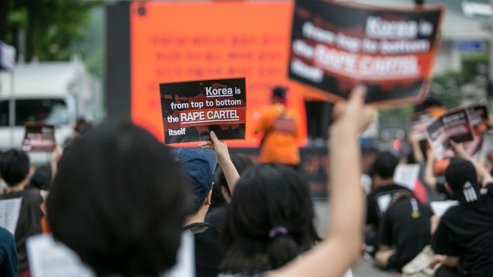 Feminists chant slogans as they hold signs that read, 'Korea is from top to bottom the Rape Cartel itself', during a rally on July 27, 2019 in Seoul, South Korea.