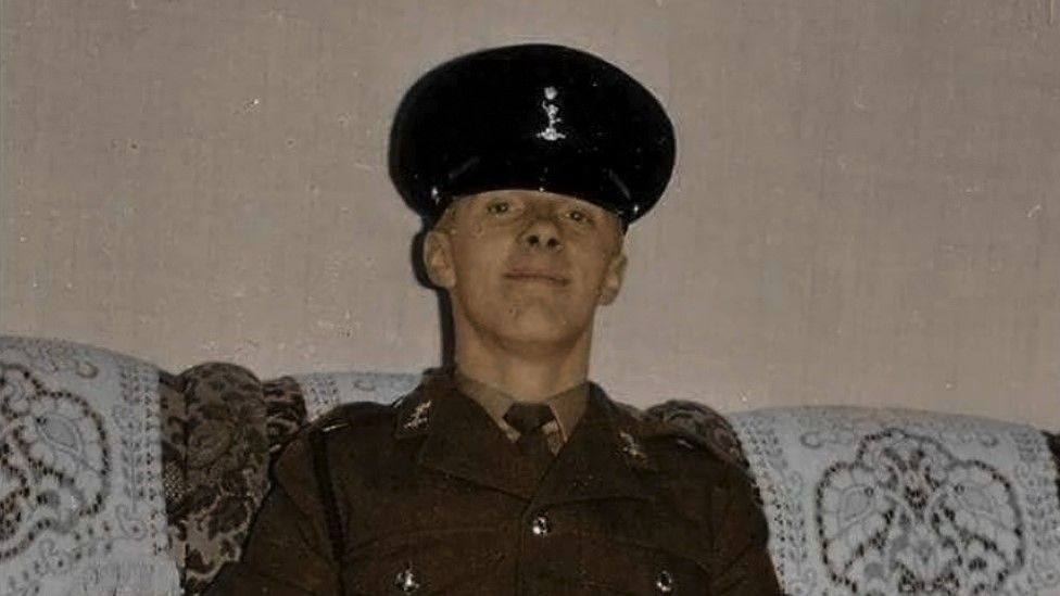 young soldier Trevor Skingle poses for camera sat on a sofa