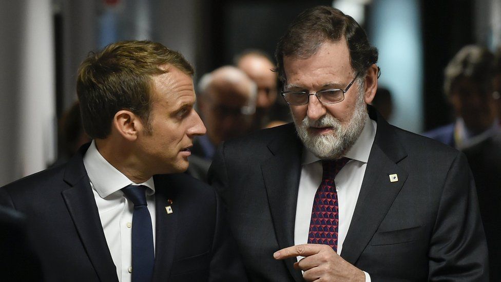 French President Emmanuel Macron (L) talks with Spanish Prime minister Mariano Rajoy (R) prior to their meeting, during the EU leaders summit on the first day of the European Council in Brussels