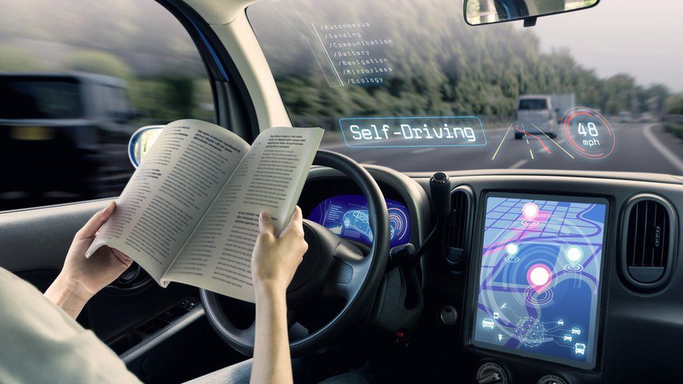 A person reading a book in an autonomous car
