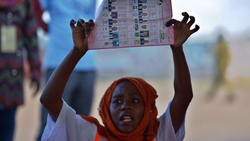 A polling station clerk holds up a ballot paper during vote counting following the closure of polling stations on October 25, 2015, at the semi-autonomous archipelago of Zanzibar