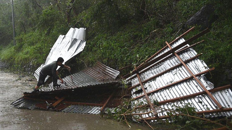 A resident tries to salvage his destroyed roof blown away at the heigh of typhoon Haima in Carranglan town on October 20, 2016.