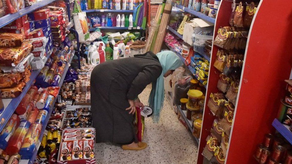 A woman looking at a shelf in a supermarket