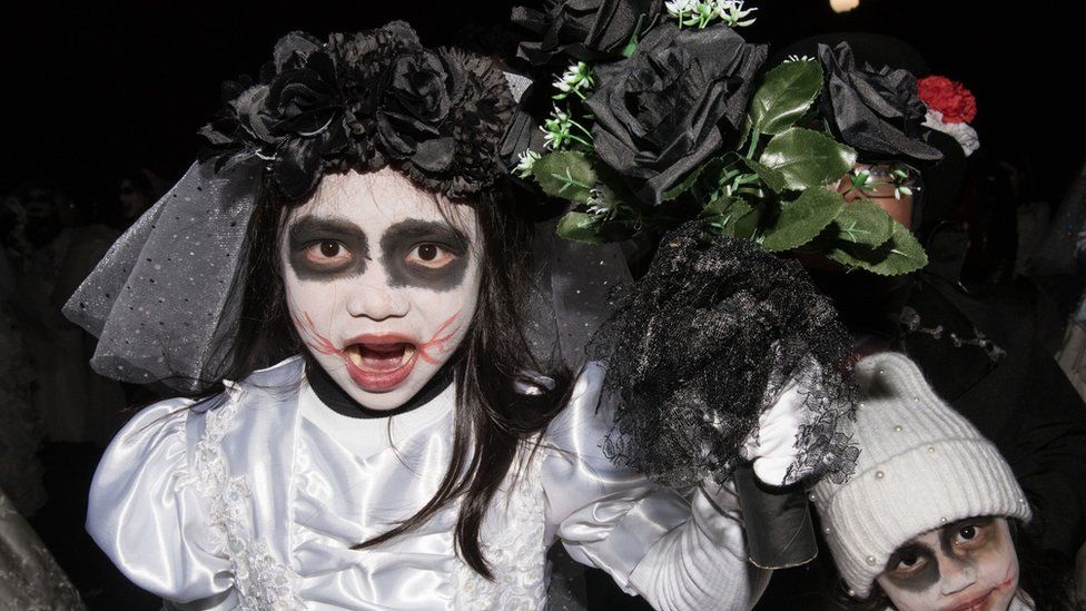 Children wearing zombie-bride costumes