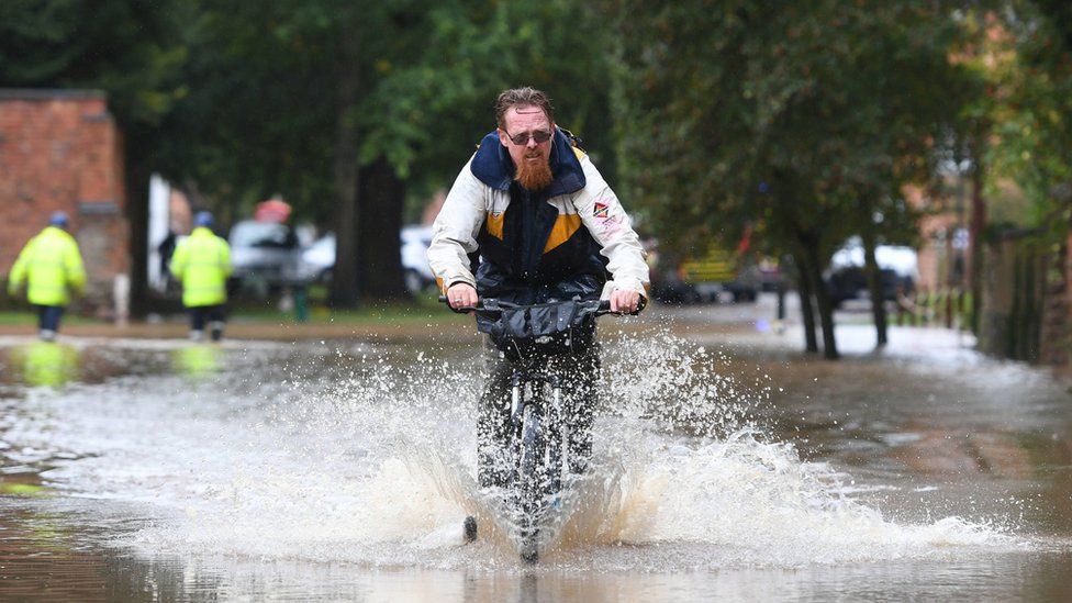 A cyclist riding through floods in Leicestershire