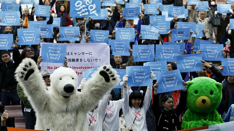 People hold placards demanding climate protection during a protest in Tokyo on Saturday