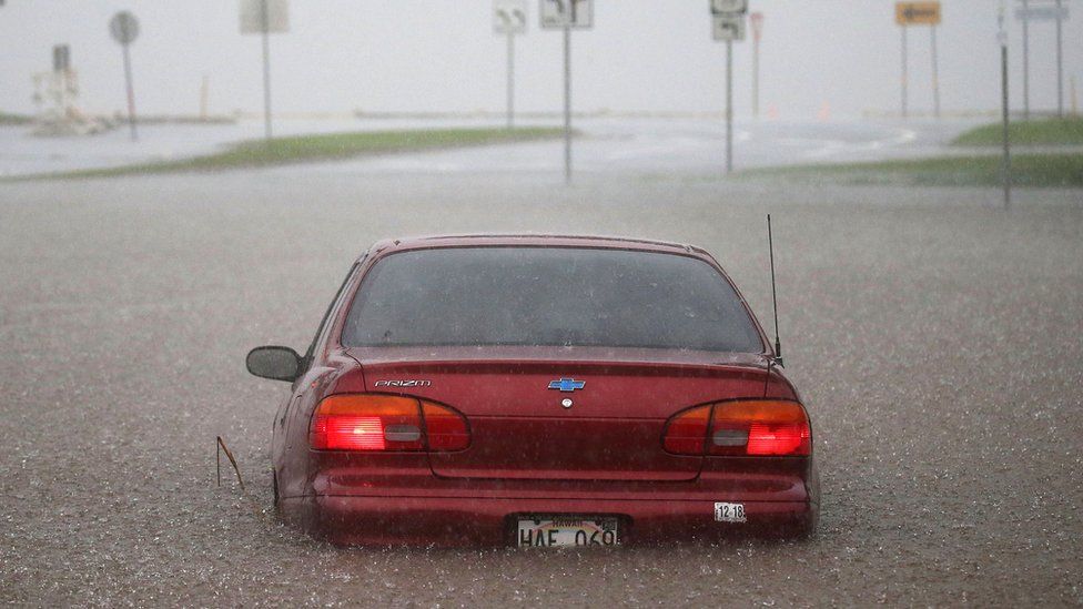 A car is stuck partially submerged in floodwaters from Hurricane Lane rainfall on the Big Island, Hawaii, 23 August 2018
