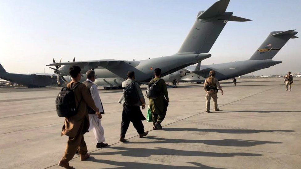 People are escorted to military planes at Kabul airport