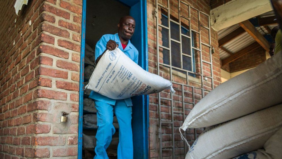 A man dressed in uniform carry large sacks of super cereal