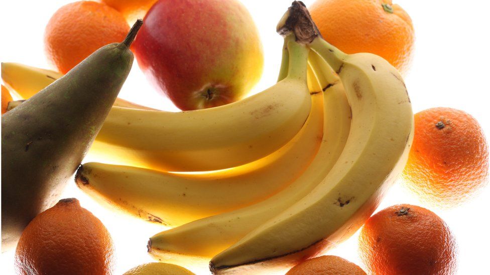 Bananas surrounded by other fruit