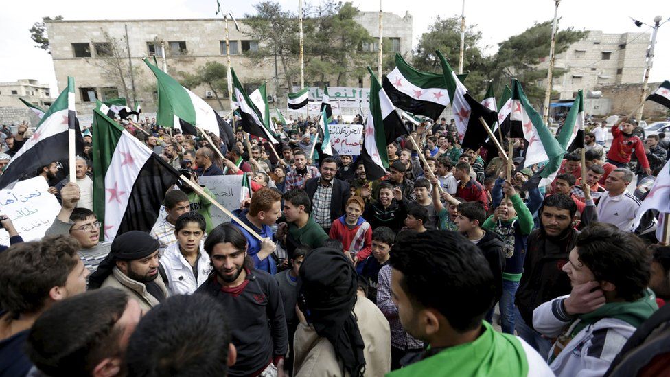 Protesters carry Free Syria Army flags and shout slogans during an anti-government protest after Friday prayers in the town of Marat Numan in Idlib province, Syria, March 11, 2016