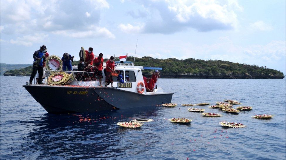 Цветы и лепестки с именами членов экипажа сбрасываются в море недалеко от Лабухан Лаланг, Бали, Индонезия 26 апреля 2021 г.