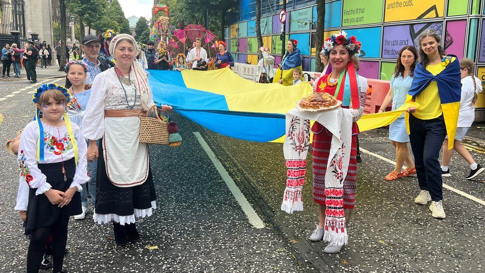 A group holding a large Ukrainian flag in the Mela parade