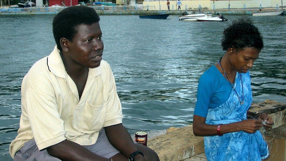 Mion (L), a member of near extinct Great Andamanese aboriginal tribe, sits with his sister, Ichika, by the waterfront in Port Blair.