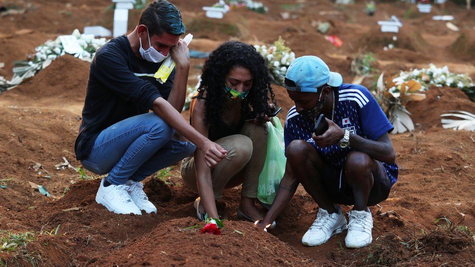 Relatives mourn at cemetery in Brazil