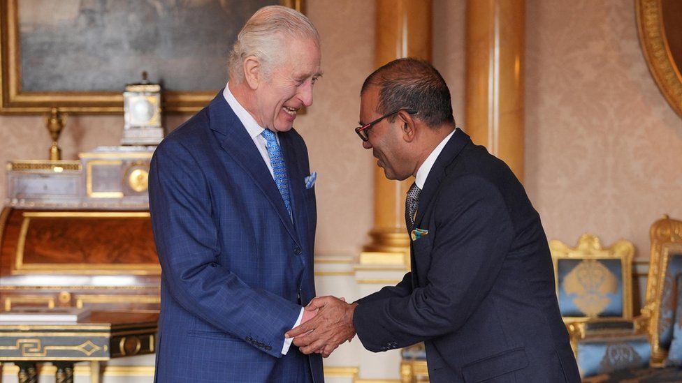 King Charles smiles and shakes hands with Mohamed Nasheed, Secretary-General of the Climate Vulnerable Forum, at Buckingham Palace