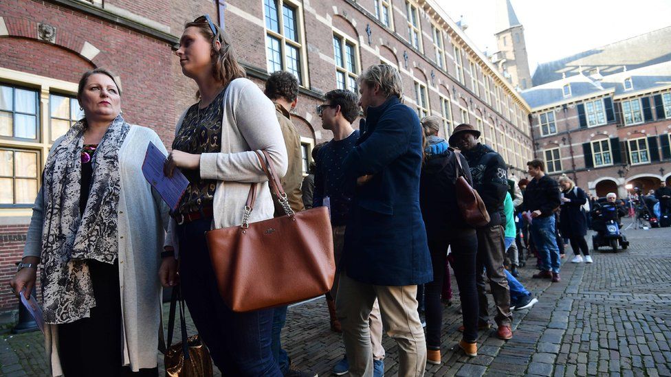 People wait in line to vote in the Dutch general e