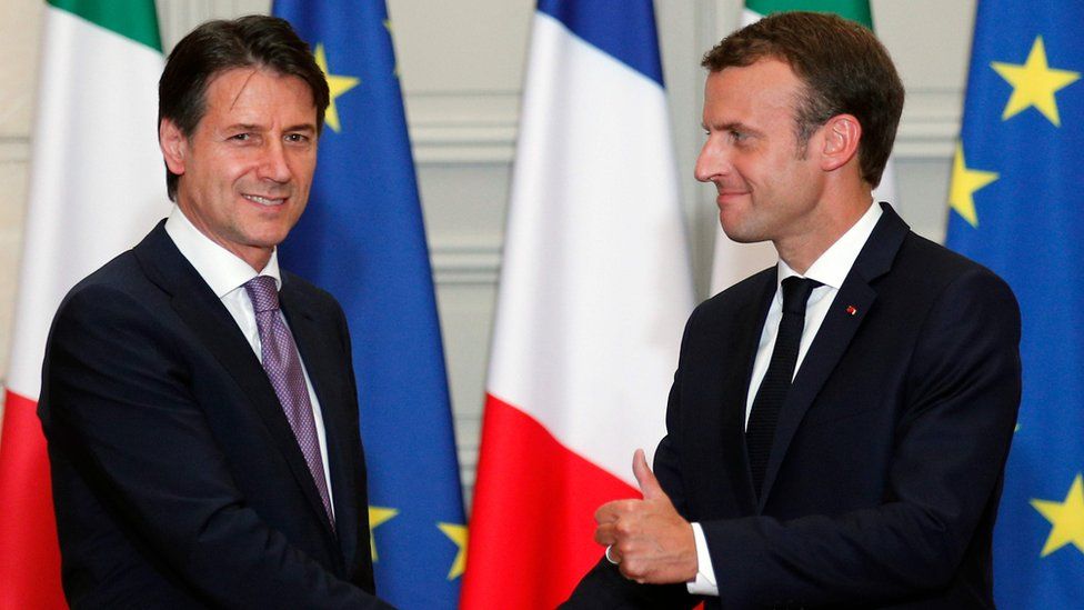French President Emmanuel Macron (R) and Italian Prime Minister Giuseppe Conte shake hands after a joint press conference following their meeting at the Elysee presidential Palace in Paris