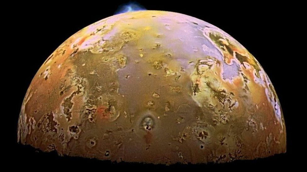 A yellow moon with an erupting volcano