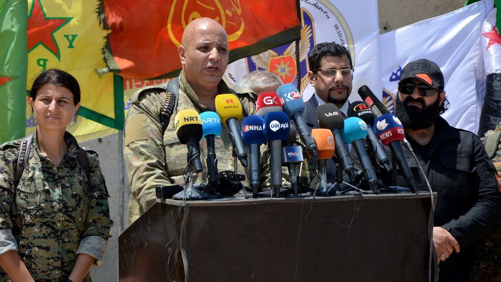 Talal Silo (C) spokesman for the Syrian Democratic Forces (SDF), speaks to reporters in the village of Hazima, Syria (6 June 2017)