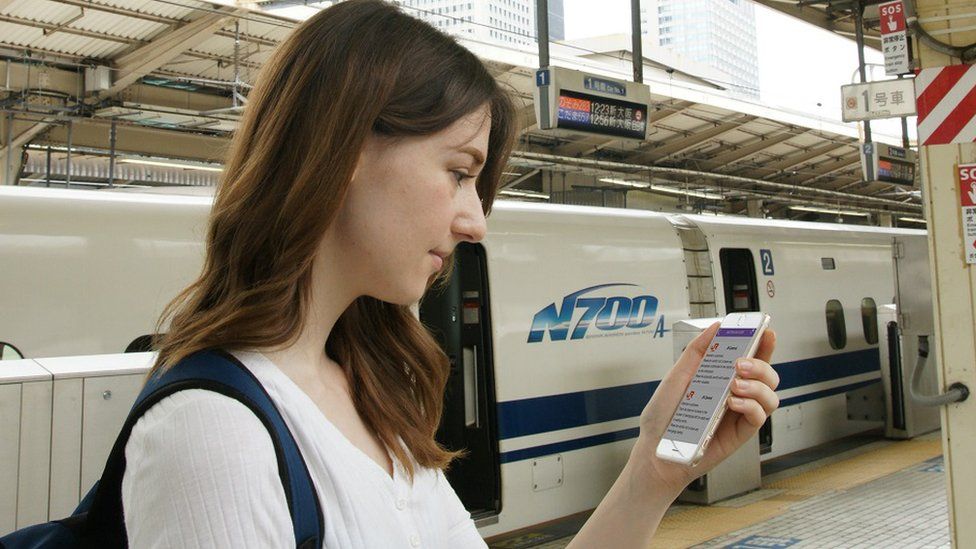 A young woman looking at the app on her mobile phone in a Tokyo station