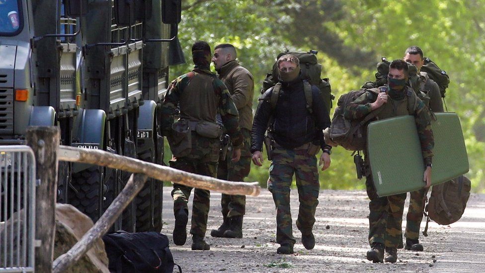 Belgian army members carry their bags at National Park Hoge Kempen