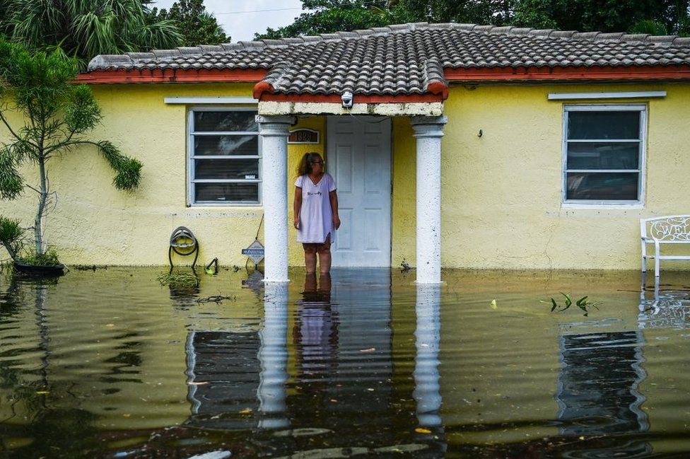 A woman looks on as she stands outside of her flooded home after heavy rain in Fort Lauderdale, Florida on April 13, 2023.