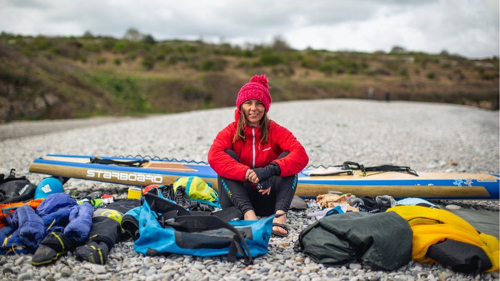 Sian Sykes on a beach with her kit