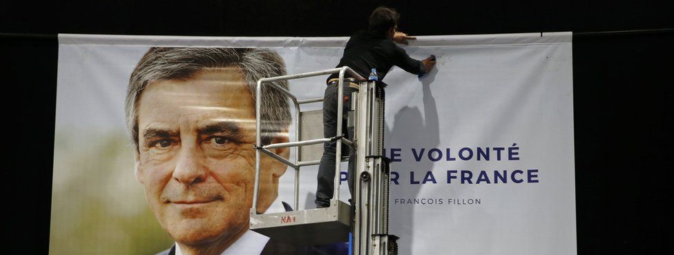 A worker installs a poster to support François Fillon, former French Prime Minister (18 April)