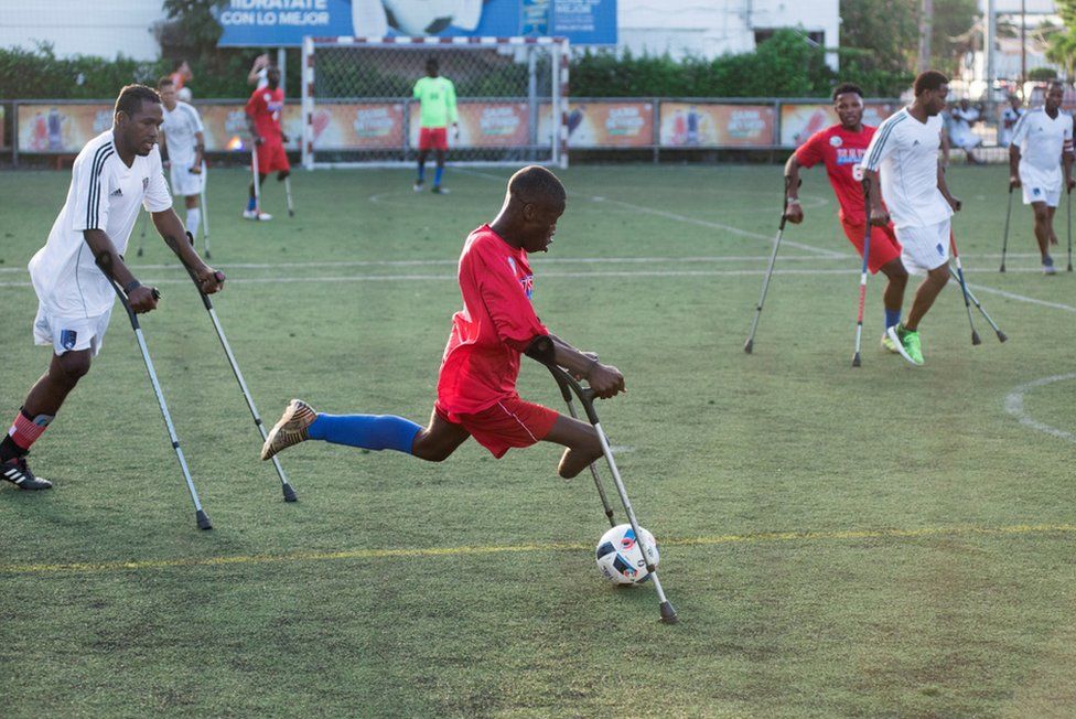 A football player from the Haiti team and survivor of the 2010 earthquake, in action during the "Two Crutches And A Ball" event, held on the tenth anniversary of the earthquake in Haiti, in Santo Domingo, Dominican Republic.