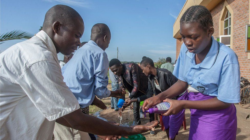 Parishioners wash hands as a preventive measure against the spread of the COVID-19 coronavirus