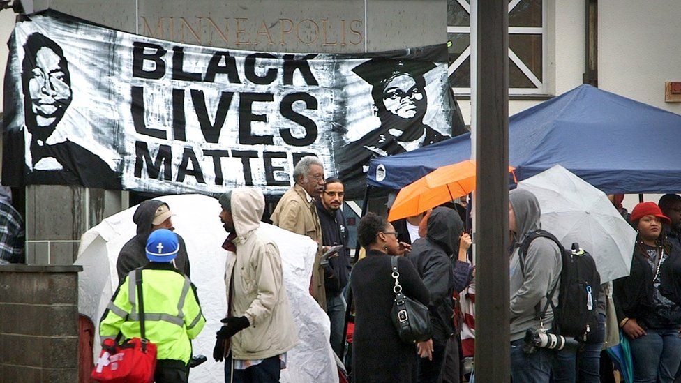 Demonstrators in front of a Black Lives Matter banner